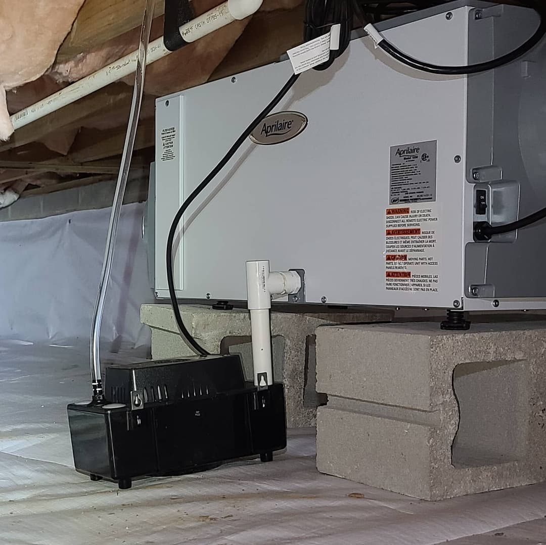 Aprilaire dehumidifier installation with condensation pump in a crawl space.