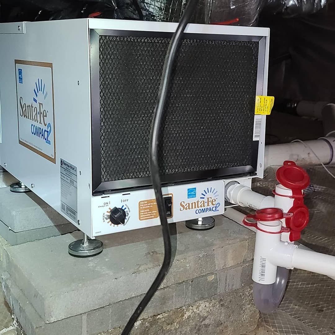 Santa Fe Compact2 dehumidifier installed in a basement for moisture control.