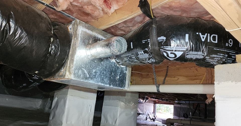 HVAC ductwork and ventilation system in a residential crawl space with insulation.
