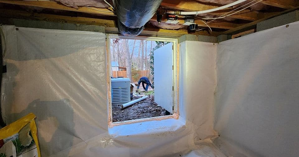 Basement window opening showing outdoor worksite and insulation details.