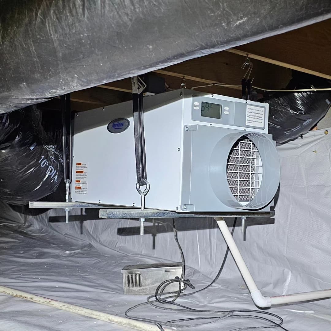 Ducted dehumidifier installed in a residential crawl space for moisture control.