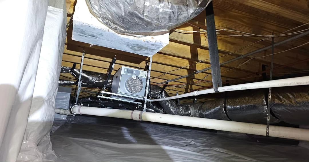 HVAC system installation in a residential attic with exposed ductwork and insulation.