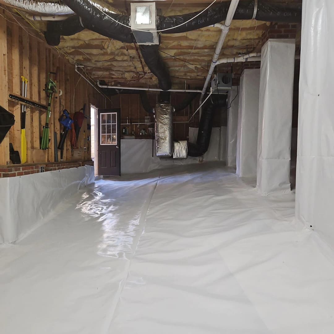 Clean, encapsulated basement with white vapor barrier and well-lit entrance.
