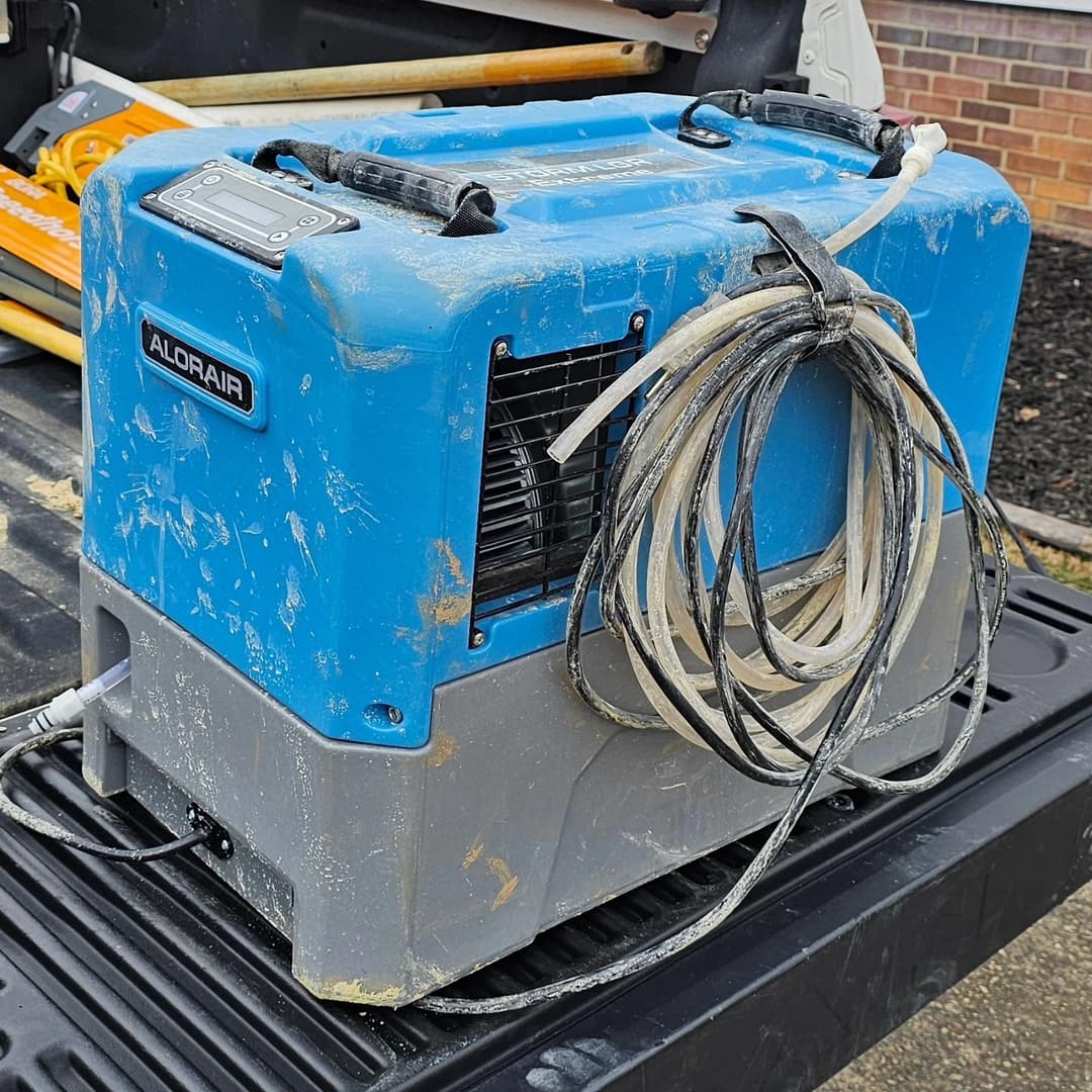 Aldorair portable dehumidifier on a pickup truck bed, showing dust and wear.