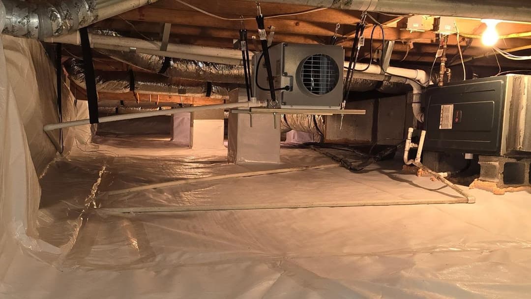 Clean, sealed basement with HVAC system and ducting visible under wooden beams.