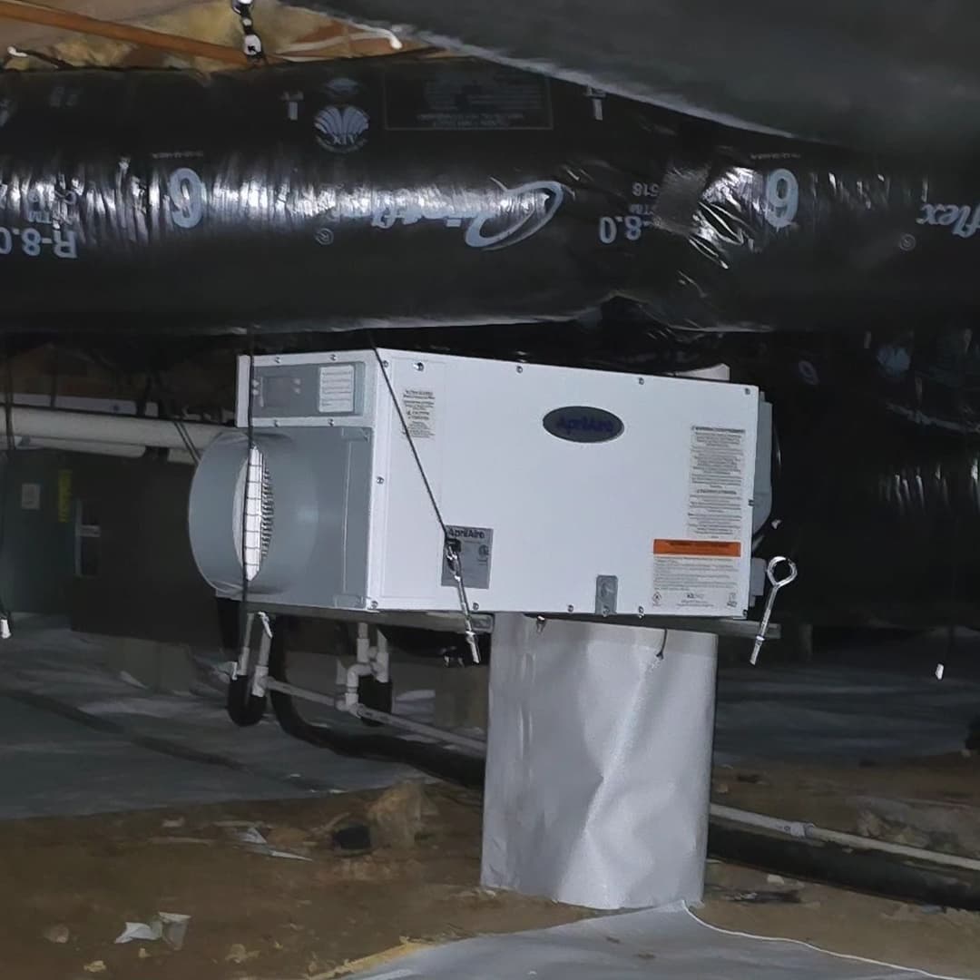 HVAC system installed in a crawl space with insulated ductwork and ventilation setup.