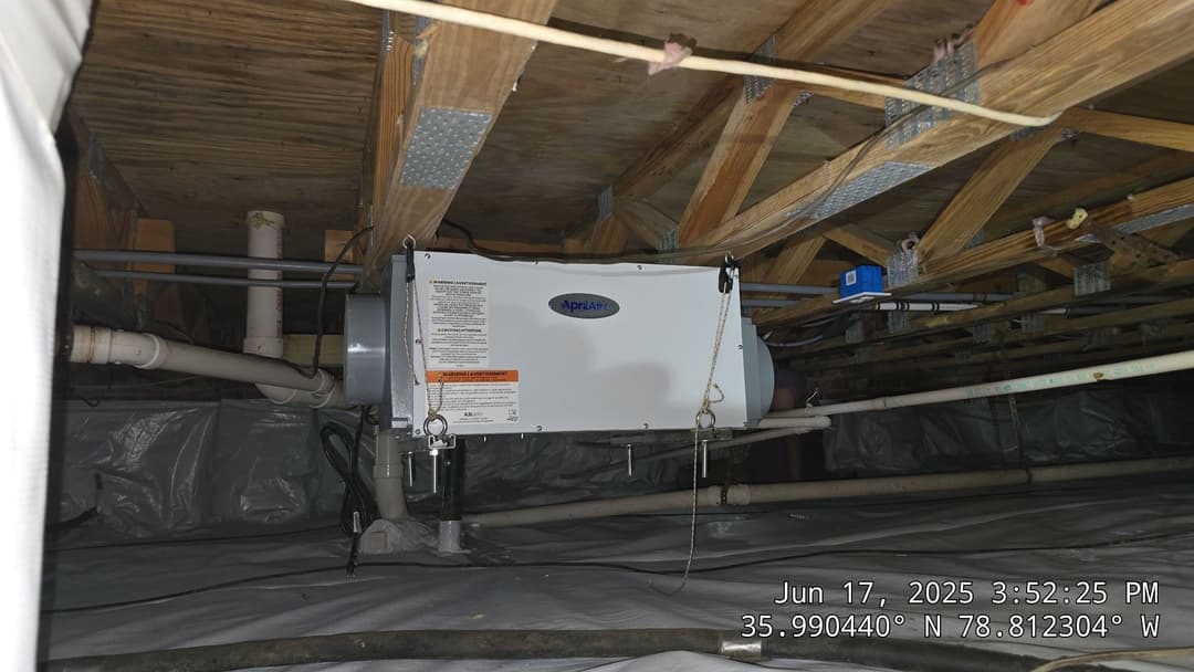 Appliances in a crawl space with ducts and insulation, enhancing home ventilation and air quality.