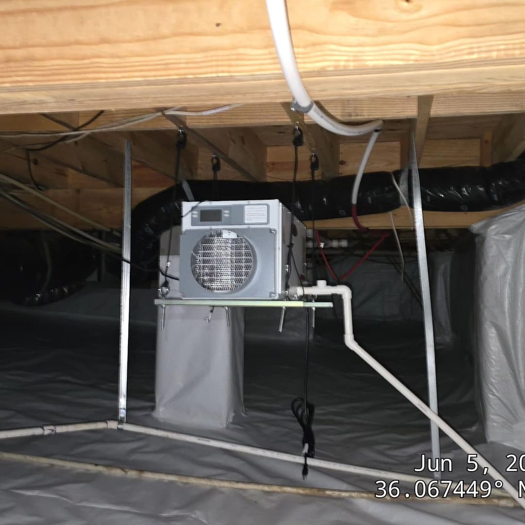 Attic ventilation system installed beneath wooden beams with PVC piping.