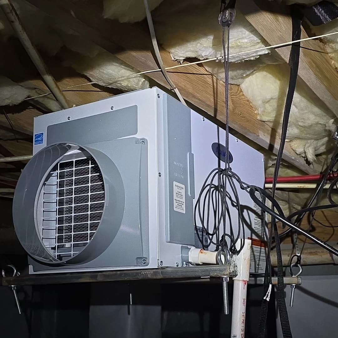 Ventilation fan installed in a ceiling, equipped with electric wiring and insulation above.